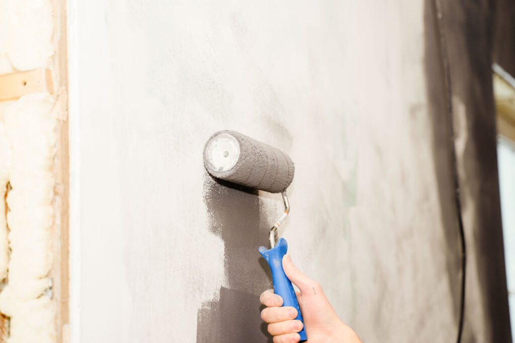 paint the walls gray with a roller rolling paint