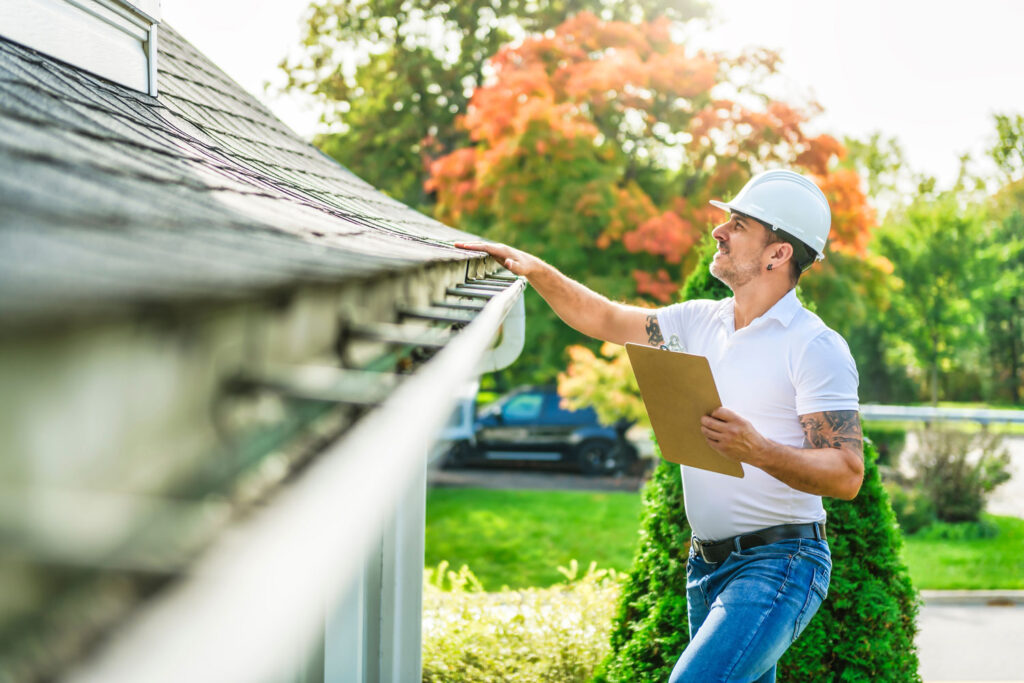 an inspector is looking at a roof and eaves